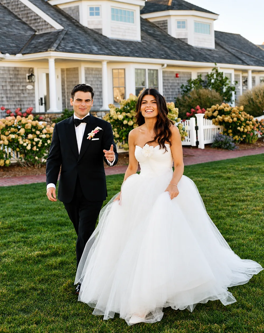 Bride and groom walking across the lawn together on their wedding day