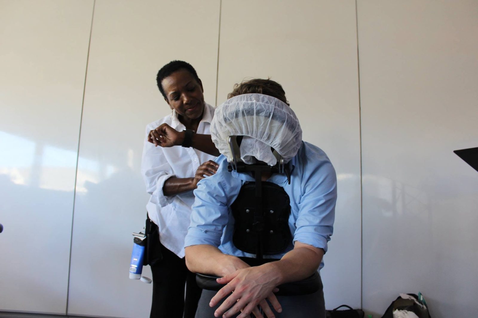 Massage therapist giving an employee a chair massage during a corporate wellness day