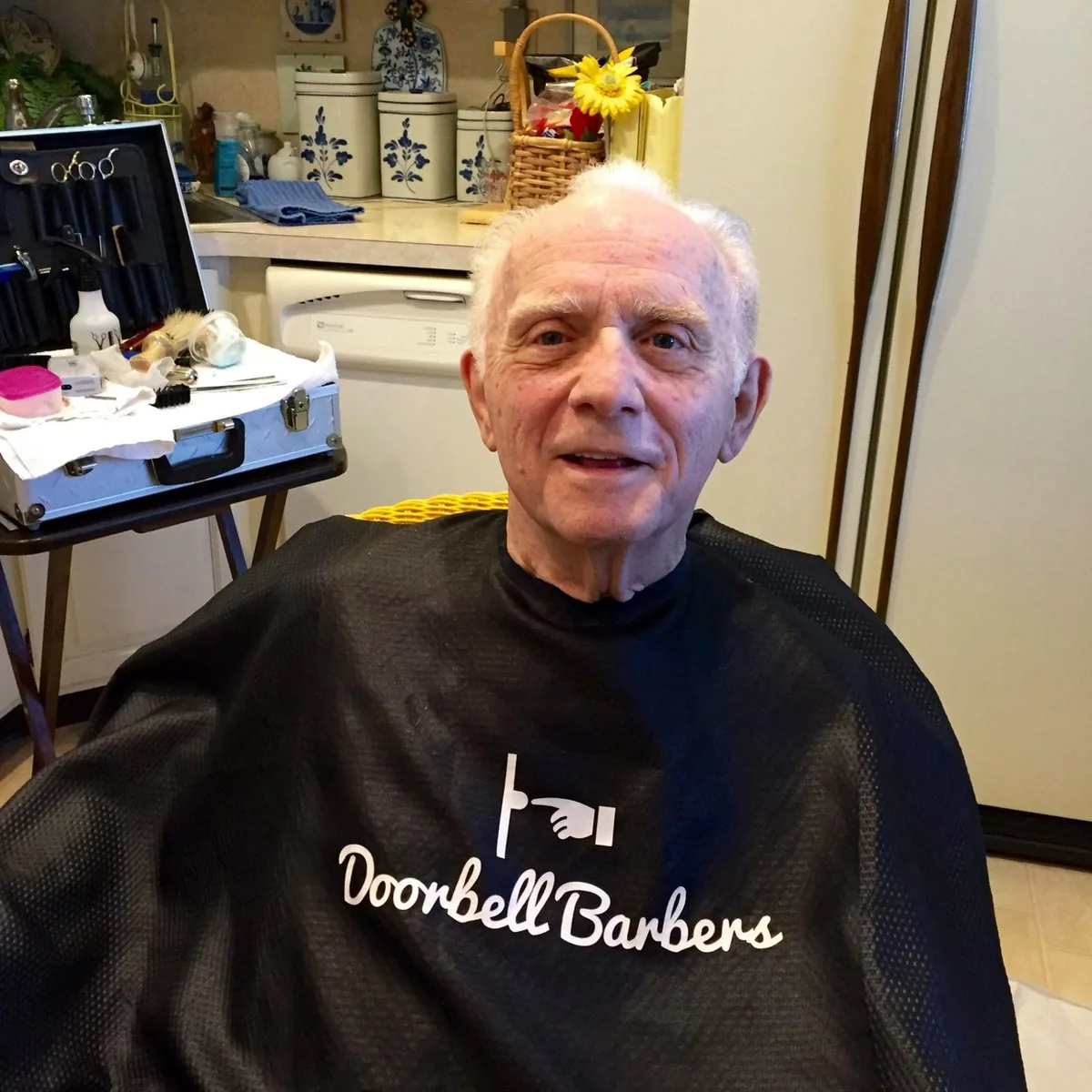 Doorbell Barbers performing an in-home senior haircut in a client's kitchen