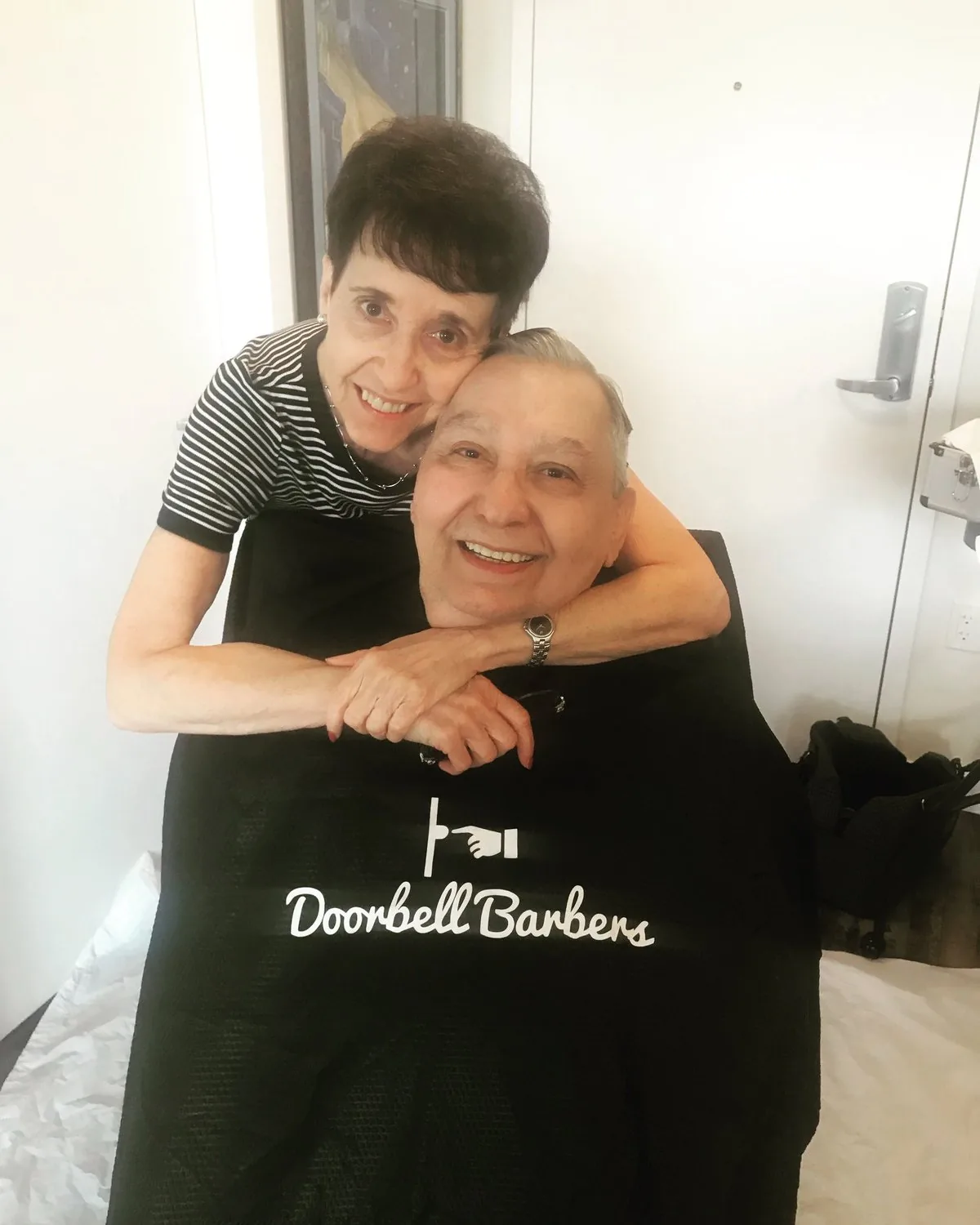 Senior client and his wife smiling warmly together after a Doorbell Barbers in-home visit