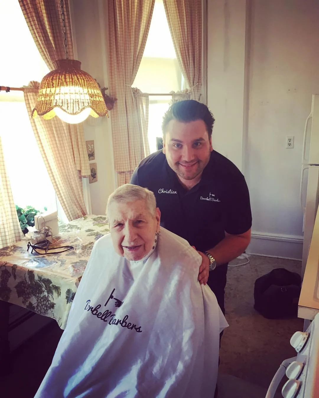 Christian, founder of Doorbell Barbers, performing an in-home haircut for a senior client