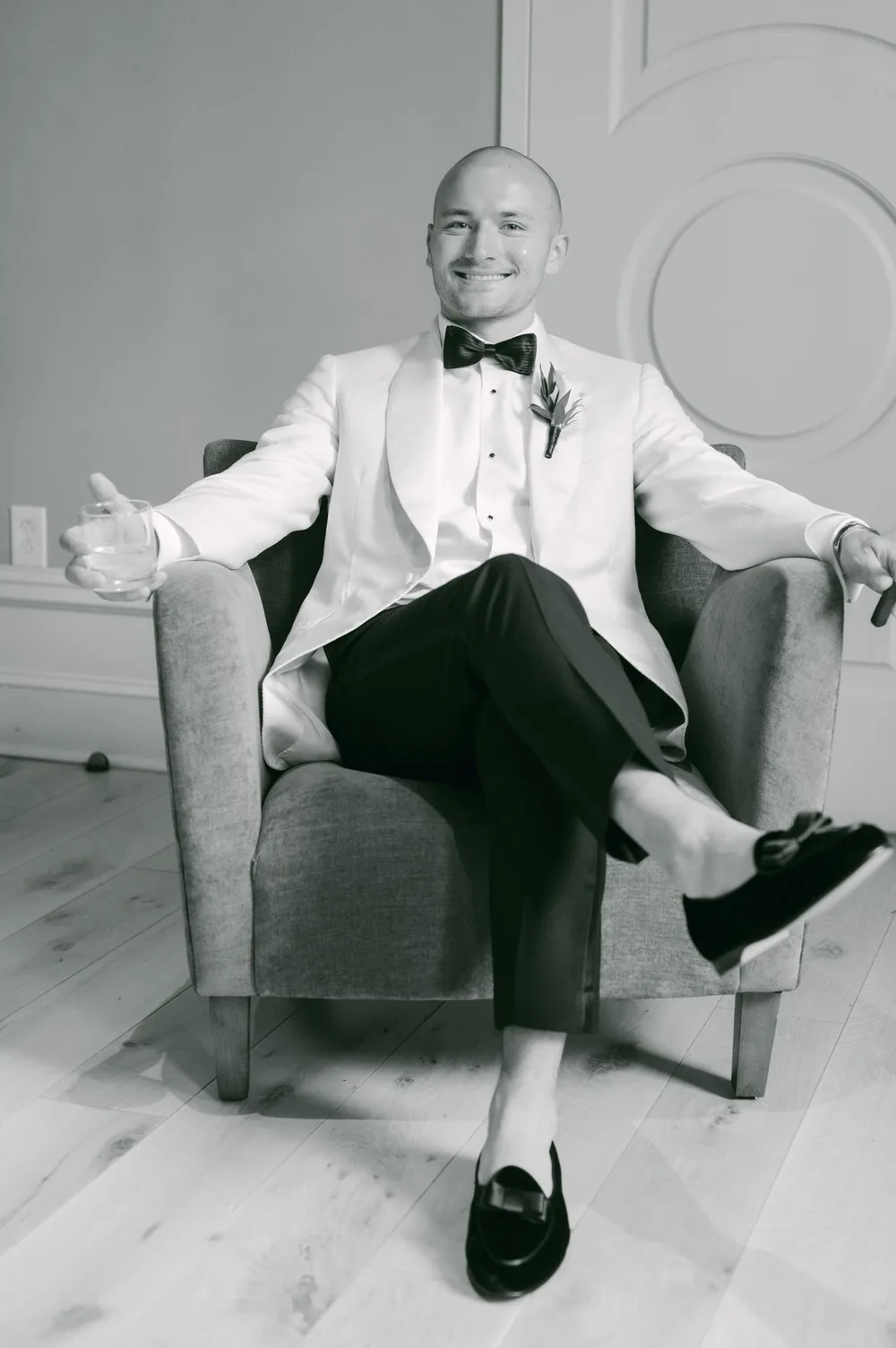 Groom in a white dinner jacket relaxing with a bourbon and cigar before the ceremony