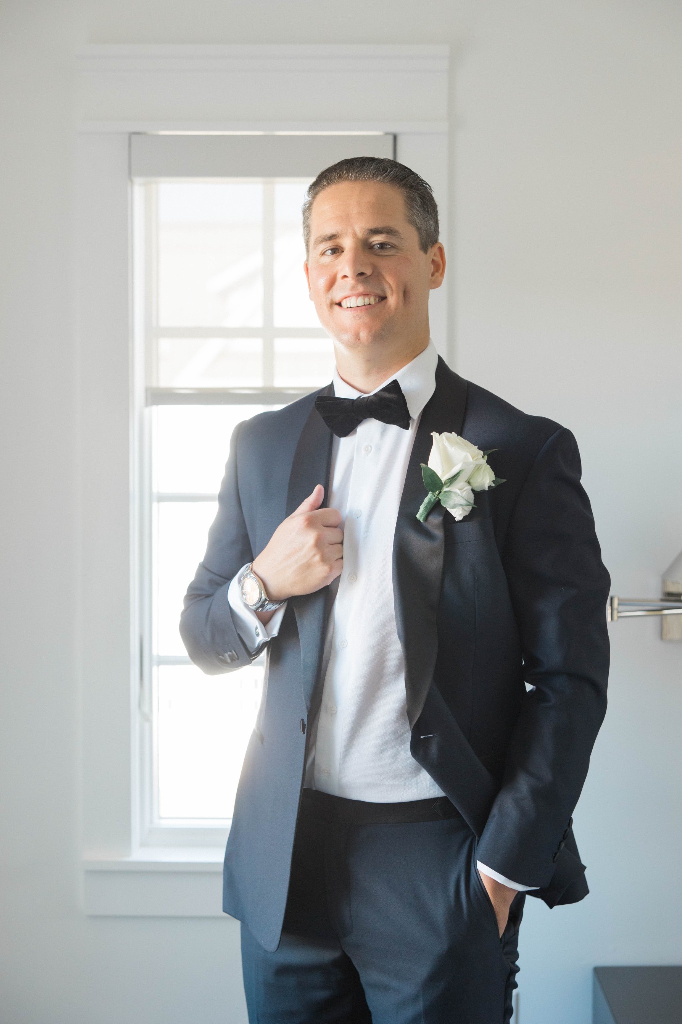 Colin smiling outdoors in black tuxedo